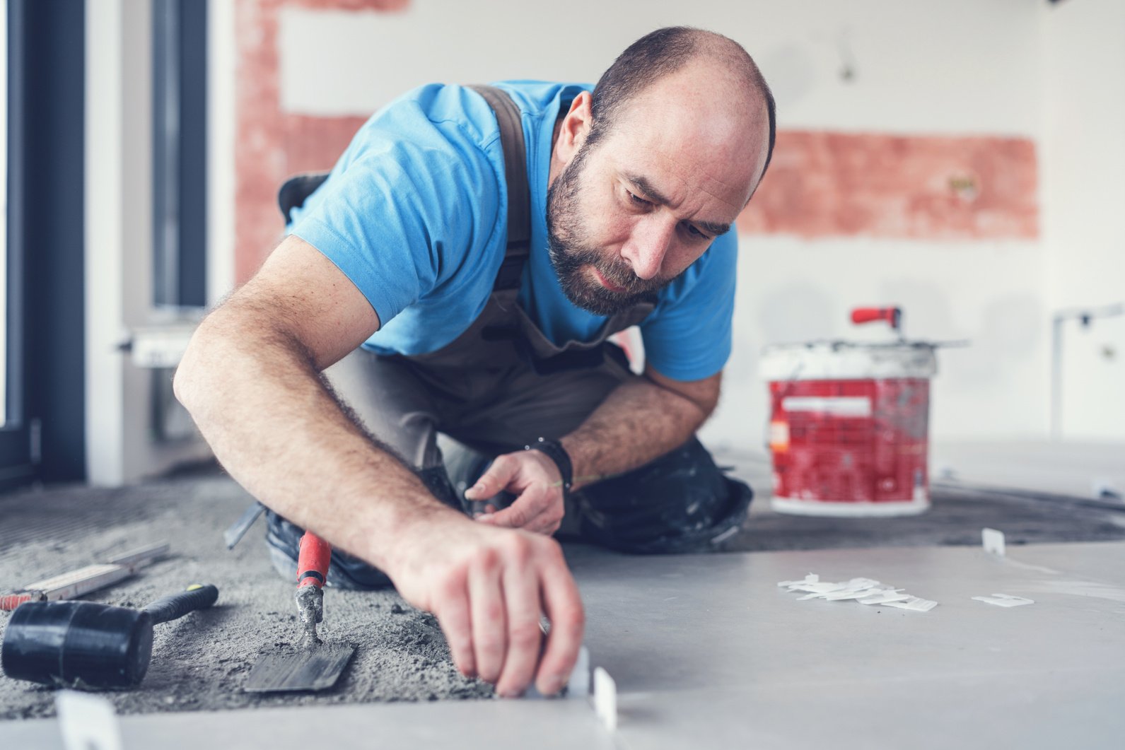 Tiler placing separators between floor tiles